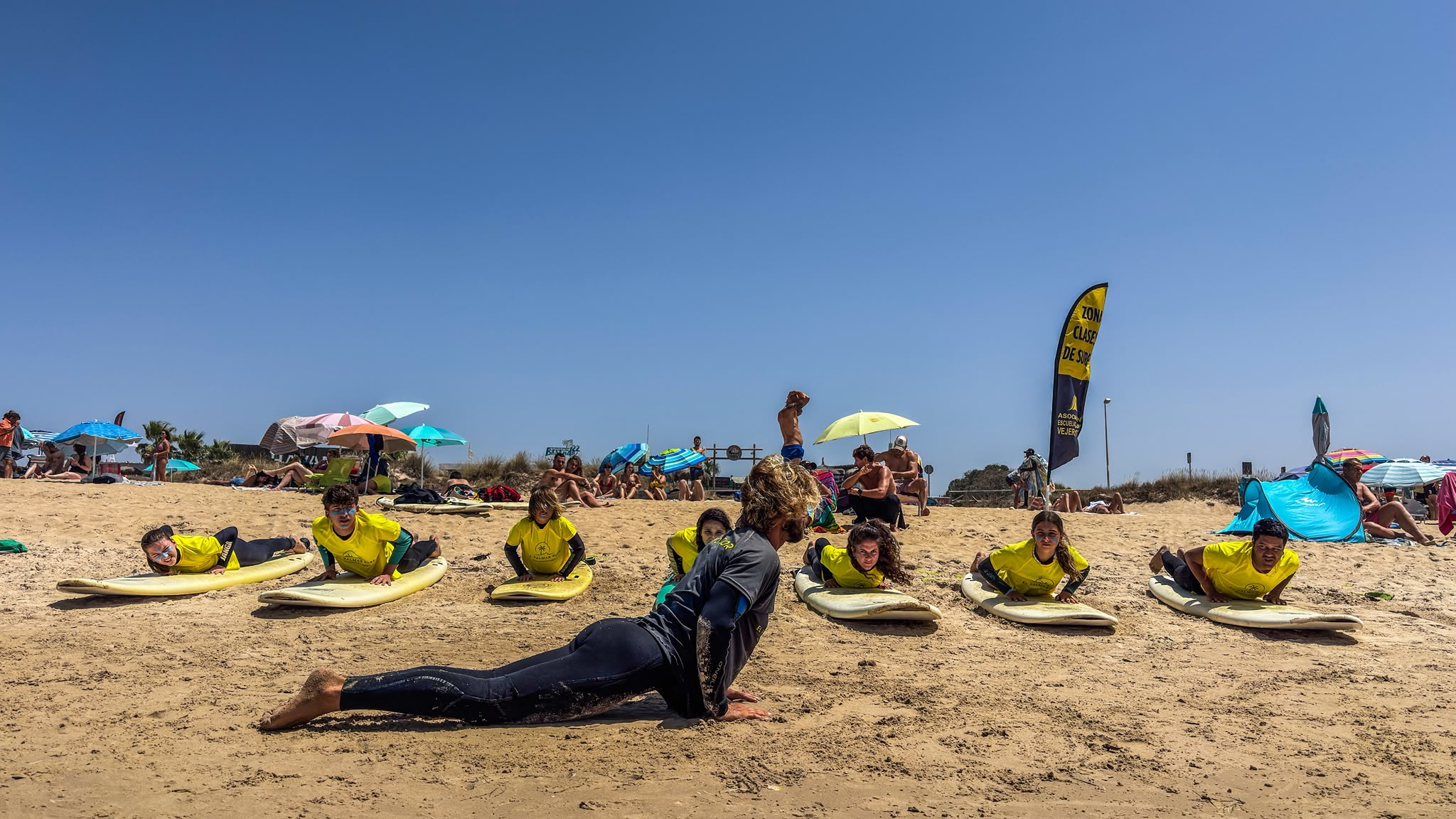 Instructores practicando el pop-up en la arena antes de entrar al agua