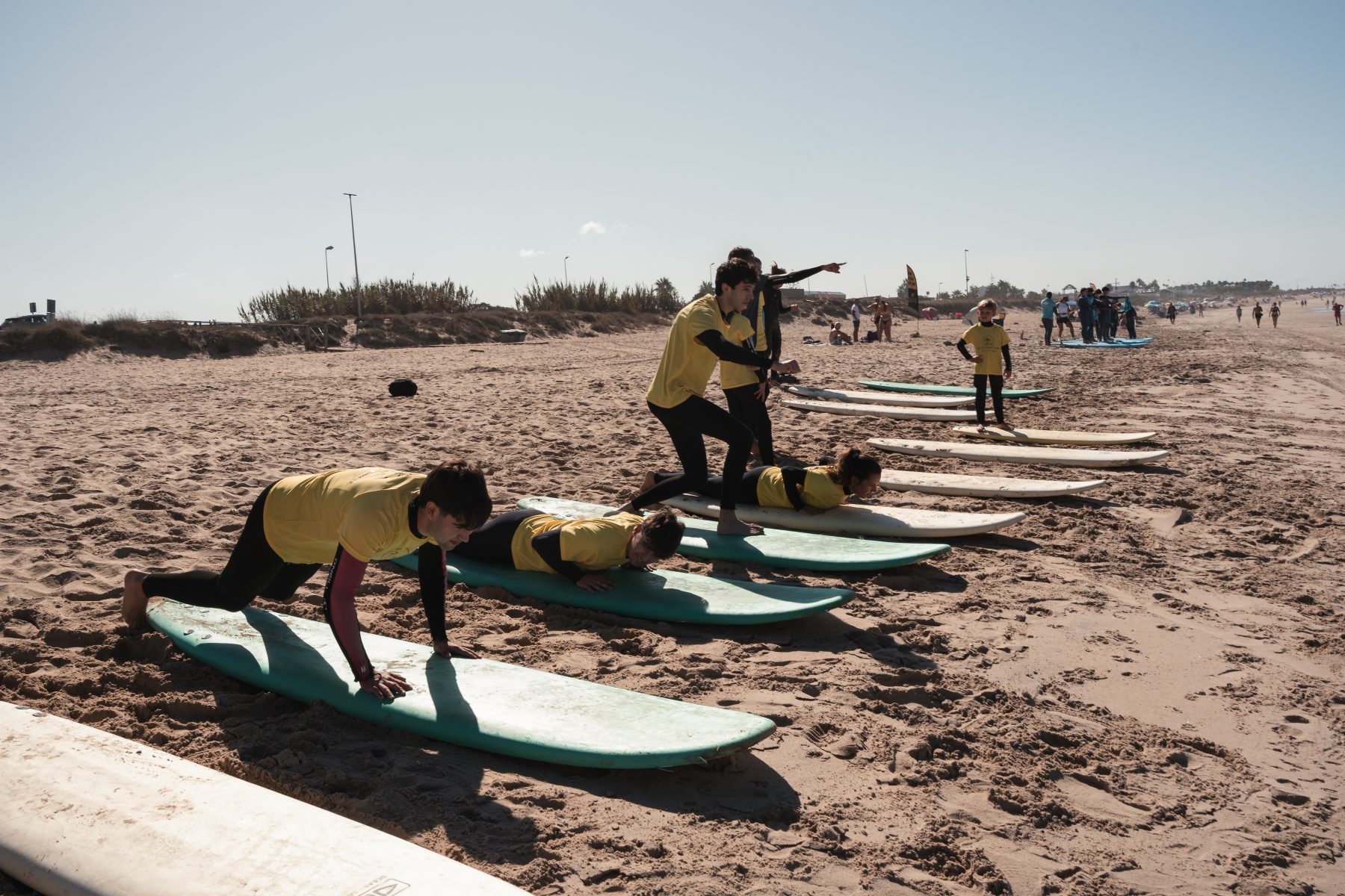 Instructores practicando el pop-up en la arena antes de entrar al agua